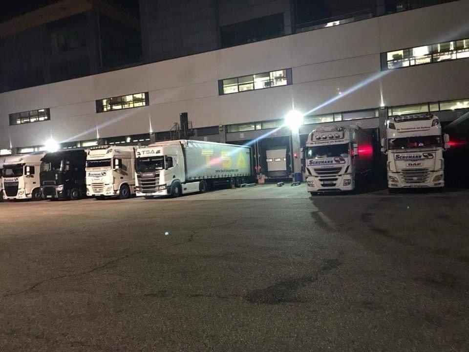 HFK trucks at a logistics depot at night